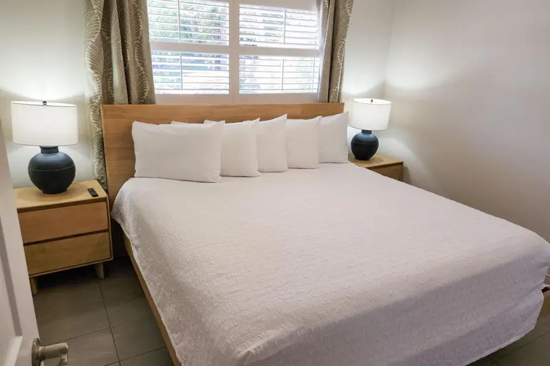 Une chambre lumineuse avec un grand lit recouvert de draps blancs.