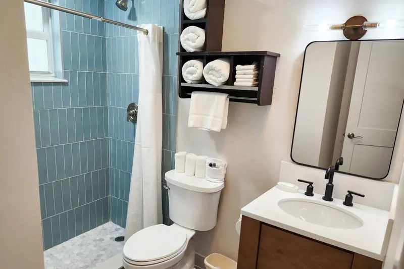 Une salle de bain claire avec douche à l'italienne et vasque.