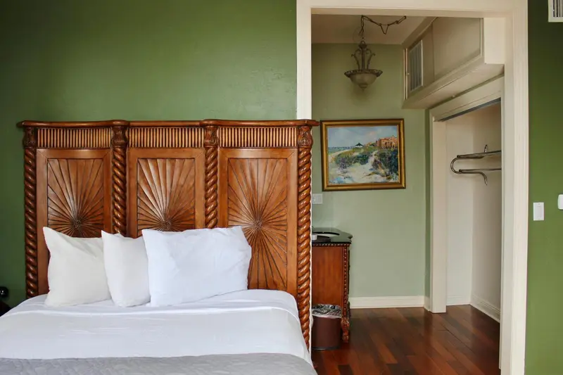 Une chambre avec un grand lit en bois sculpté et une décoration murale.
