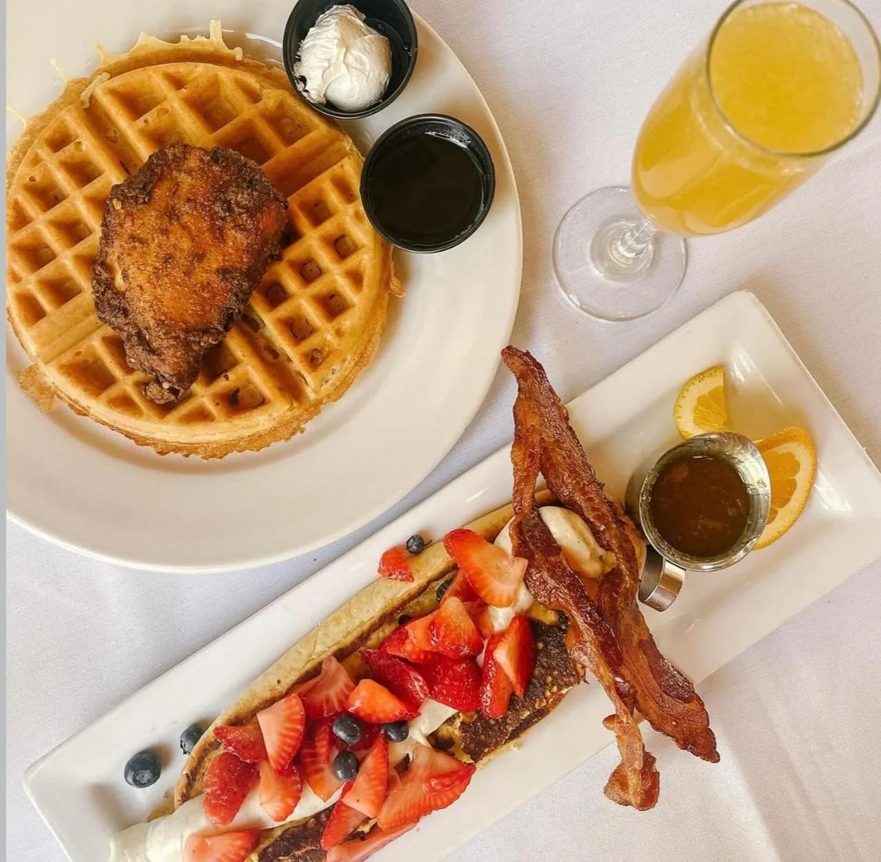 Assiette de gaufres, de poulet frit, de bacon, de fraises et de myrtilles.