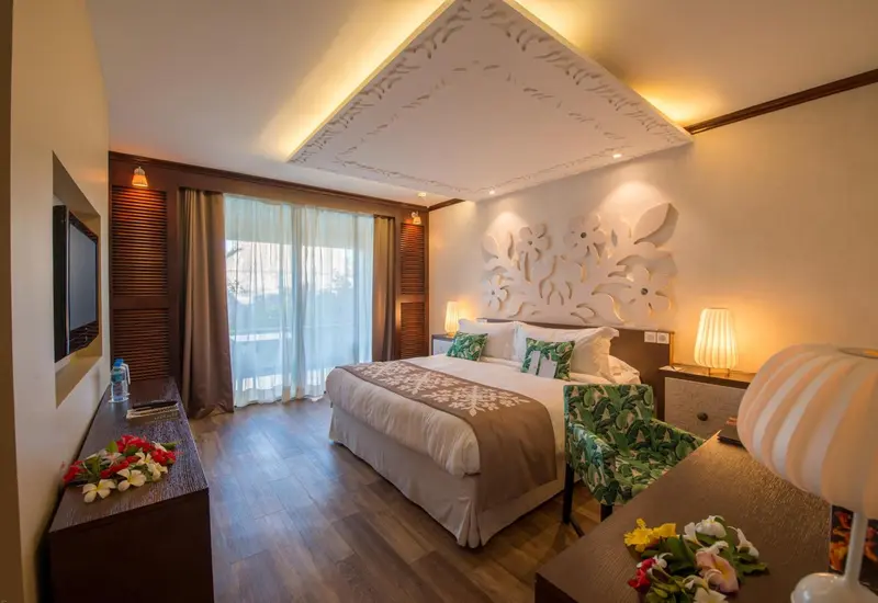 Une chambre lumineuse avec un grand lit et une décoration florale.