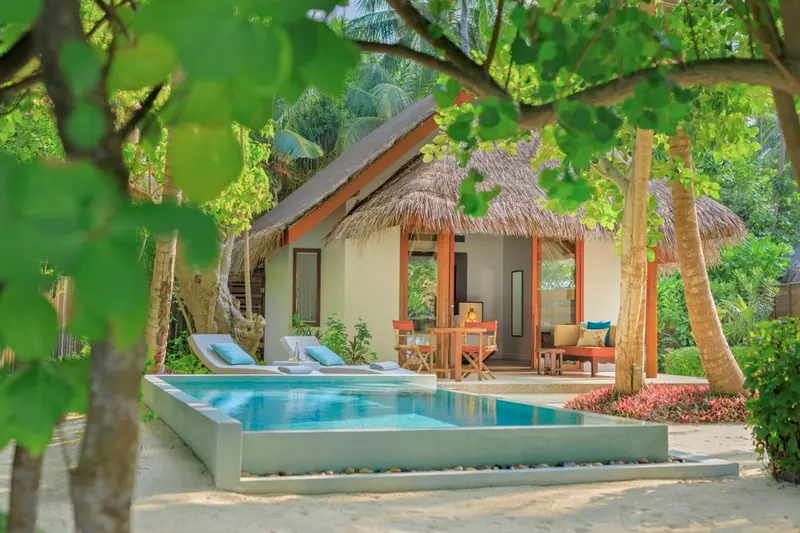 Une villa avec piscine privée et mobilier de jardin.