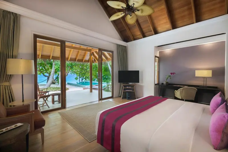 Une chambre lumineuse s'ouvre sur une terrasse avec vue sur la mer.