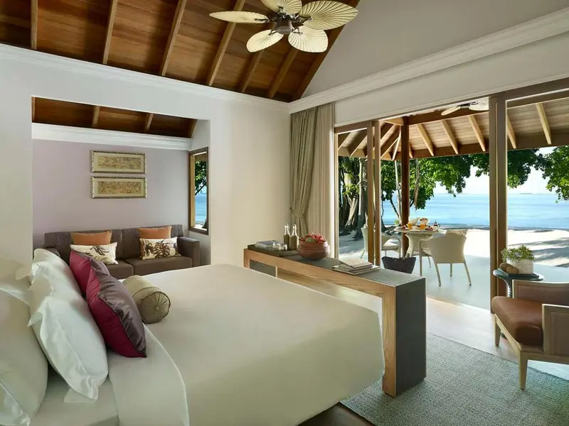 Une chambre lumineuse s'ouvre sur une terrasse avec vue sur la mer.