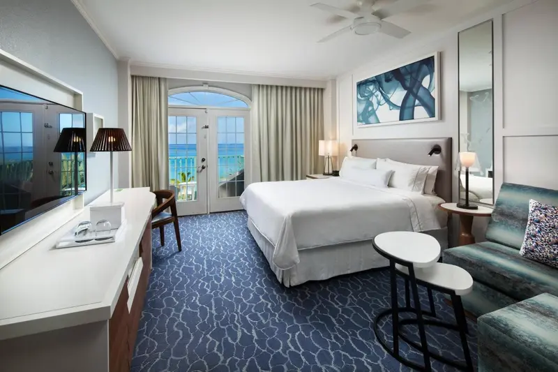 Une chambre lumineuse avec un grand lit et une vue sur la mer.