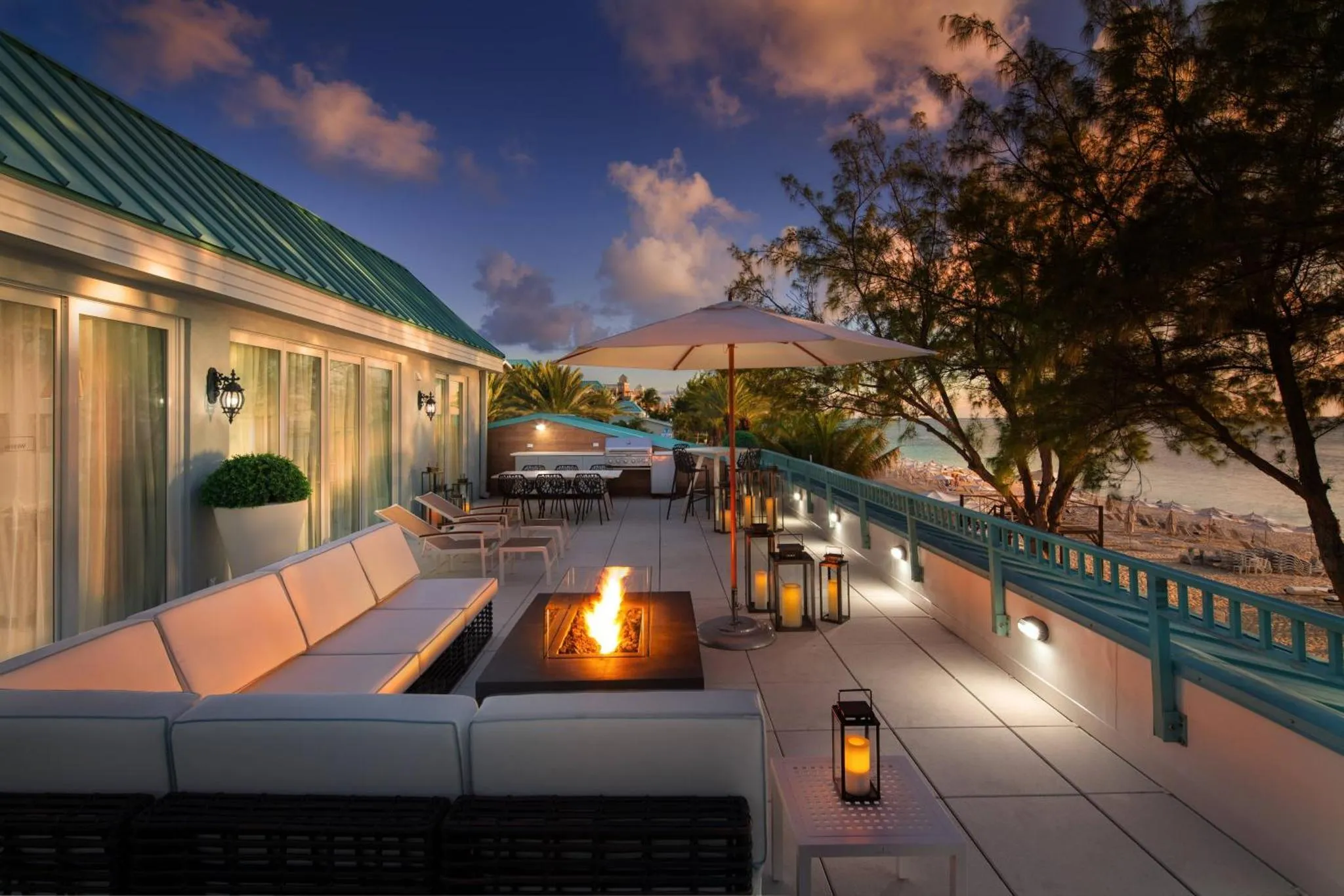 Terrasse aménagée avec salon et foyer extérieur face à la mer.