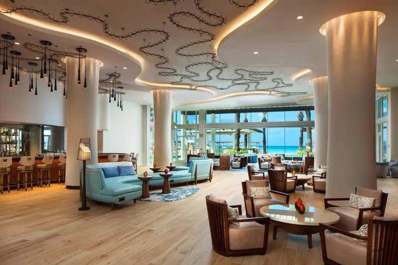 Vaste espace de réception lumineux avec mobilier contemporain et vue sur la mer.