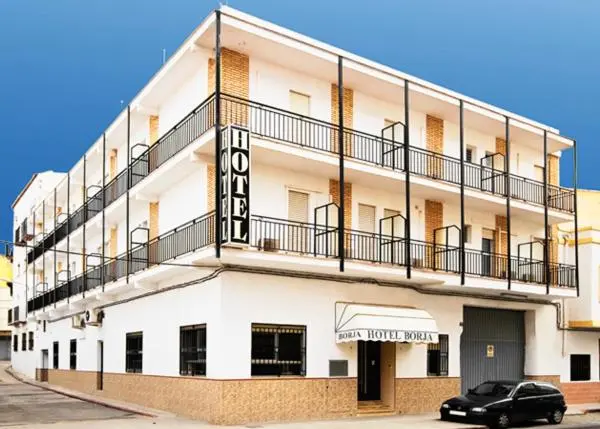 Façade d'un bâtiment blanc à plusieurs étages avec des balcons en fer forgé.