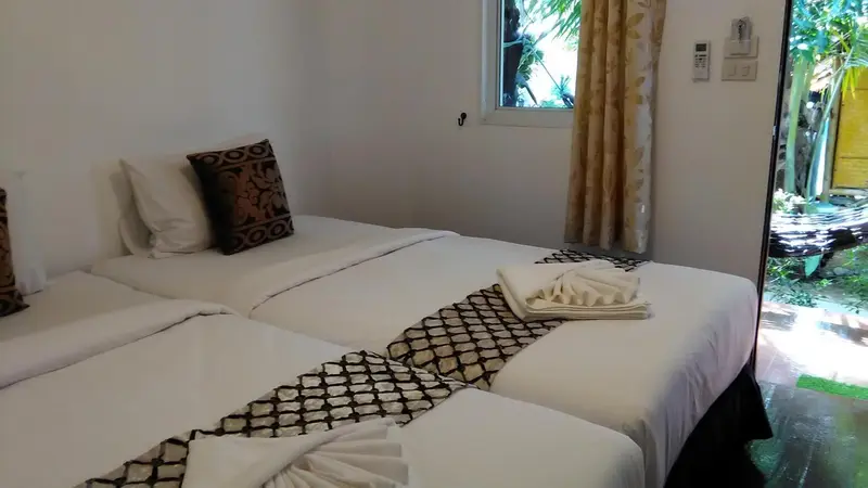 Une chambre lumineuse avec deux lits simples et une décoration sobre.