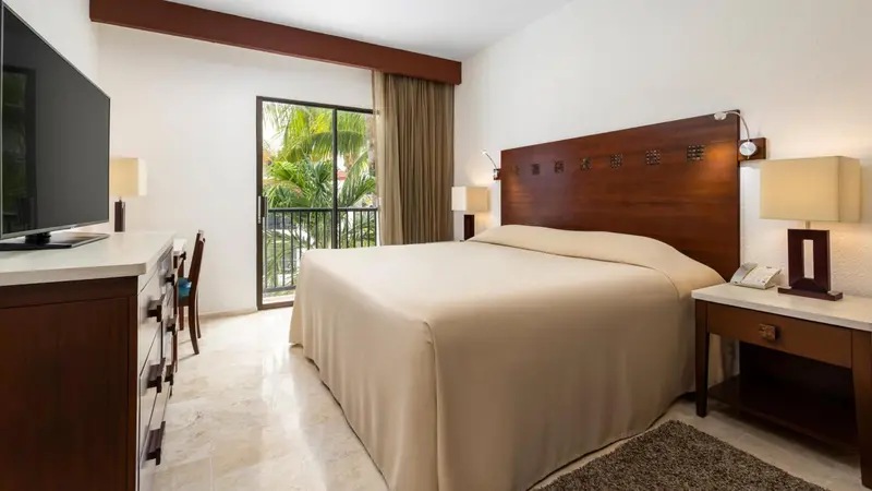 Une chambre lumineuse avec un grand lit recouvert d'une courtepointe blanche.