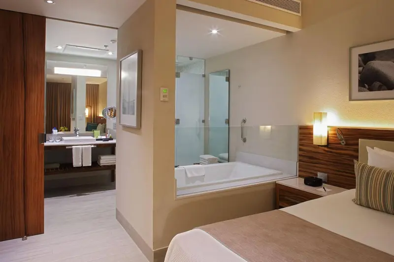 Une chambre lumineuse avec un lit et une salle de bain attenante.