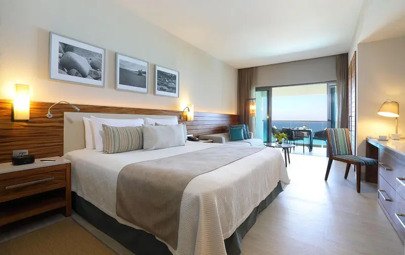 Une chambre lumineuse avec un grand lit et une vue sur la mer.