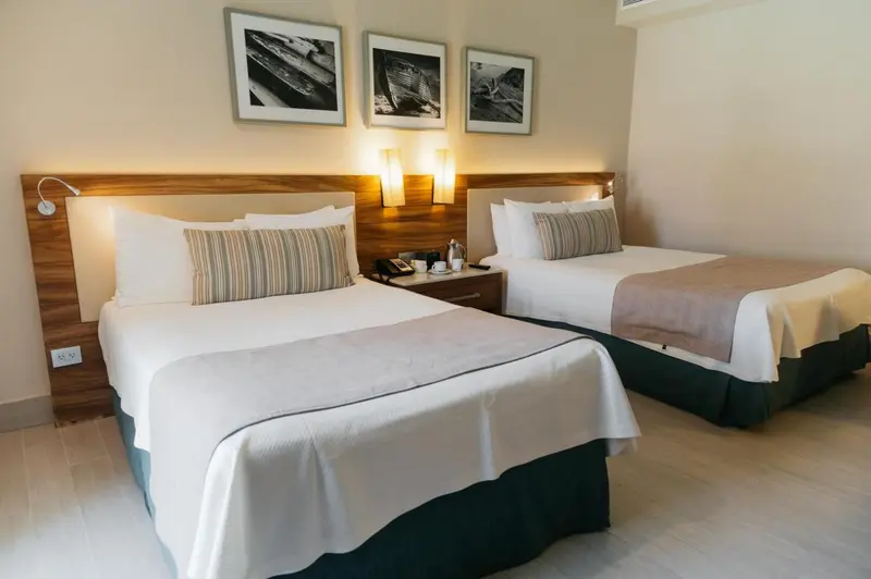 Une chambre lumineuse avec deux lits simples et une décoration sobre.