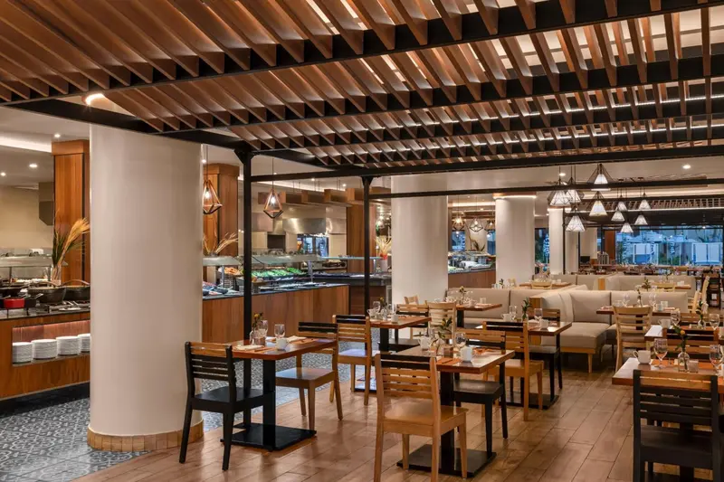 Une salle lumineuse avec des tables et des chaises pour les repas.