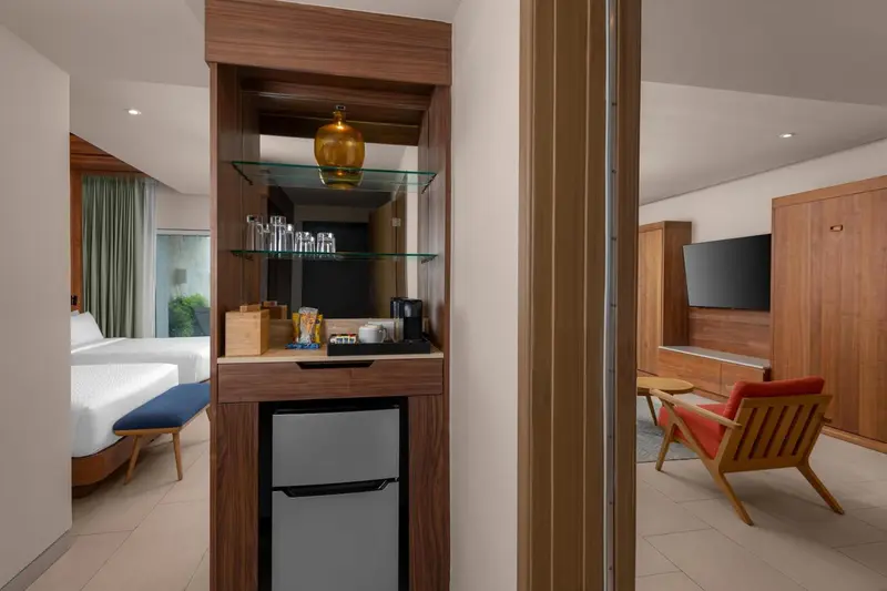 Un coin bar avec des bouteilles et une cafetière dans une chambre d'hôtel.