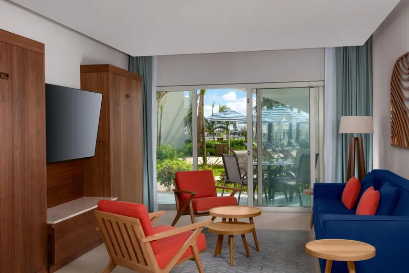 Un salon lumineux s'ouvre sur une terrasse avec mobilier de jardin.