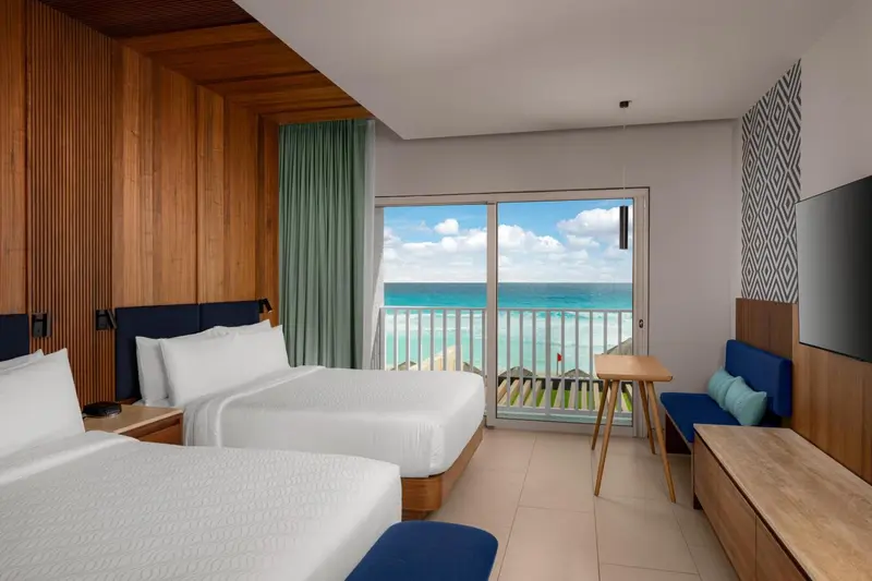 Chambre lumineuse avec vue sur la mer et un balcon.