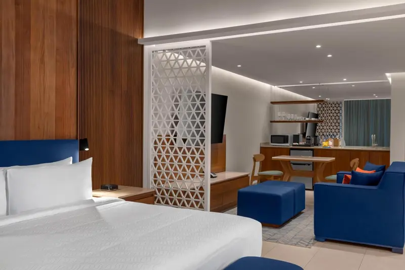 Une chambre lumineuse avec un lit double et un espace salon.