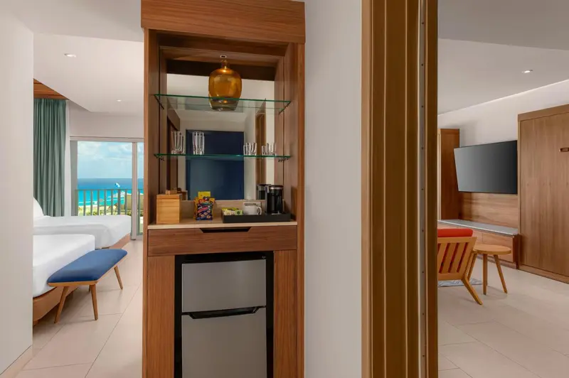 Une kitchenette en bois est visible dans une chambre lumineuse.