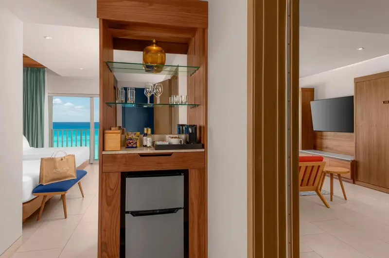 Un espace bar avec des bouteilles et un réfrigérateur dans une chambre.