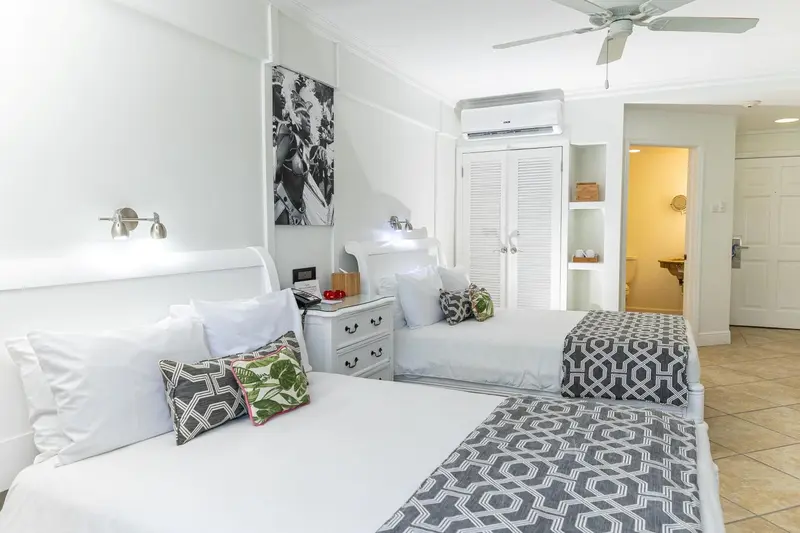 Chambre lumineuse avec deux lits simples et décoration florale.