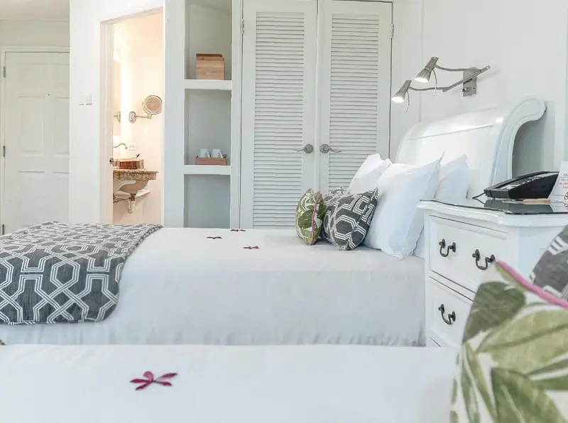 Une chambre lumineuse avec un grand lit recouvert d'une courtepointe décorative.