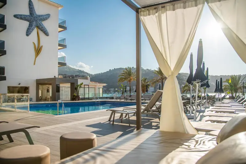 Espace de détente extérieur avec transats et piscine.