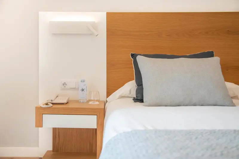 Un lit avec des oreillers dans une chambre lumineuse.