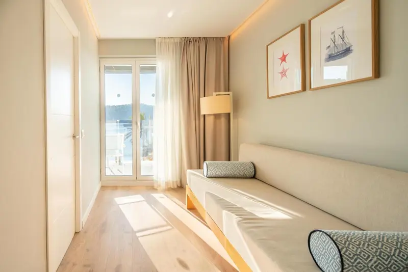 Une chambre lumineuse avec un canapé et une vue sur la mer.