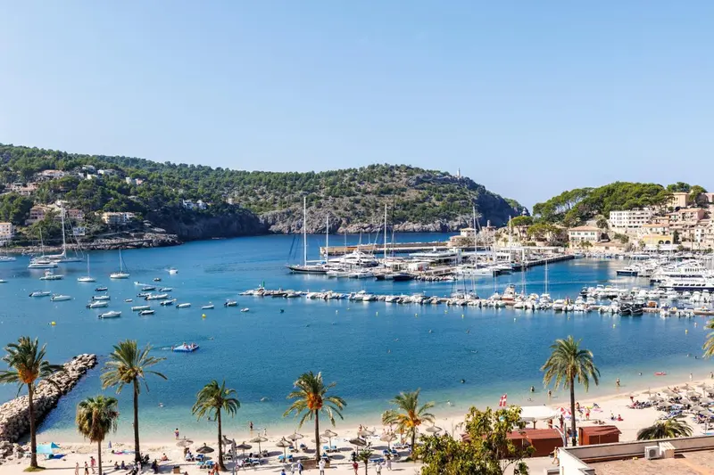 Vue aérienne d'une baie abritée avec des bateaux et une plage.