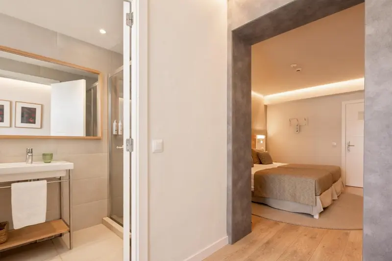 Une chambre lumineuse avec un lit et un espace lavabo.