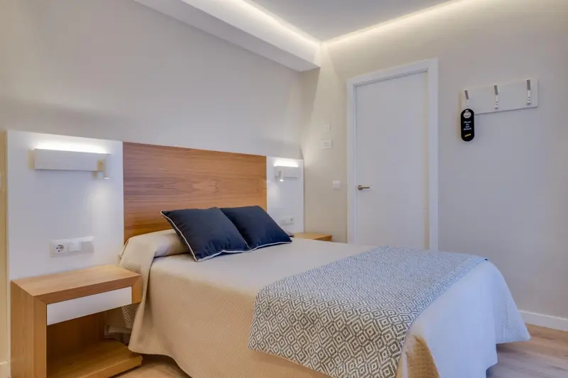 Une chambre lumineuse avec un grand lit et une décoration sobre.