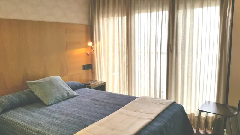 Une chambre avec un lit et une fenêtre drapée.