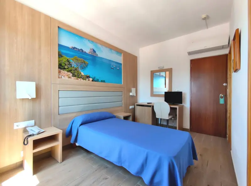 Chambre lumineuse avec un grand tableau représentant une plage.