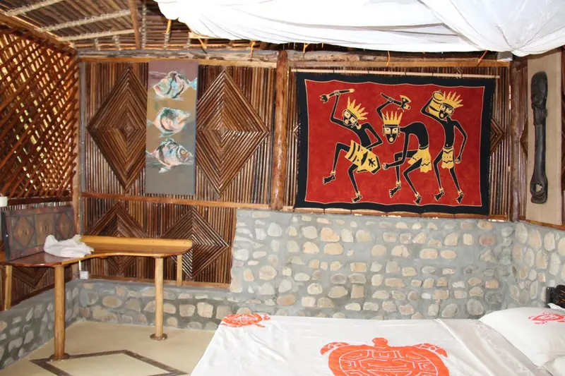Une chambre avec un lit recouvert d'une courtepointe et des tableaux décoratifs sur les murs.