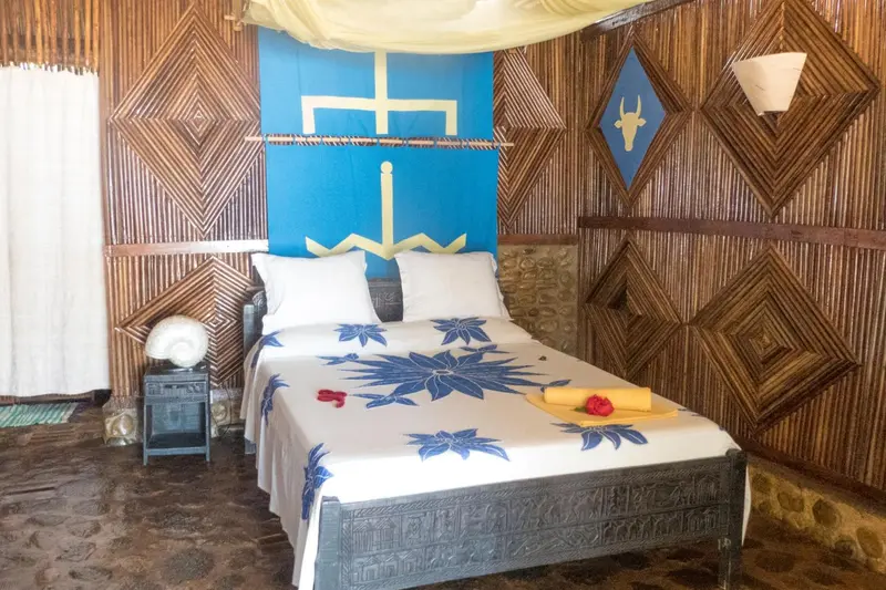 Lit recouvert d'une courtepointe fleurie dans une chambre décorée de bois.