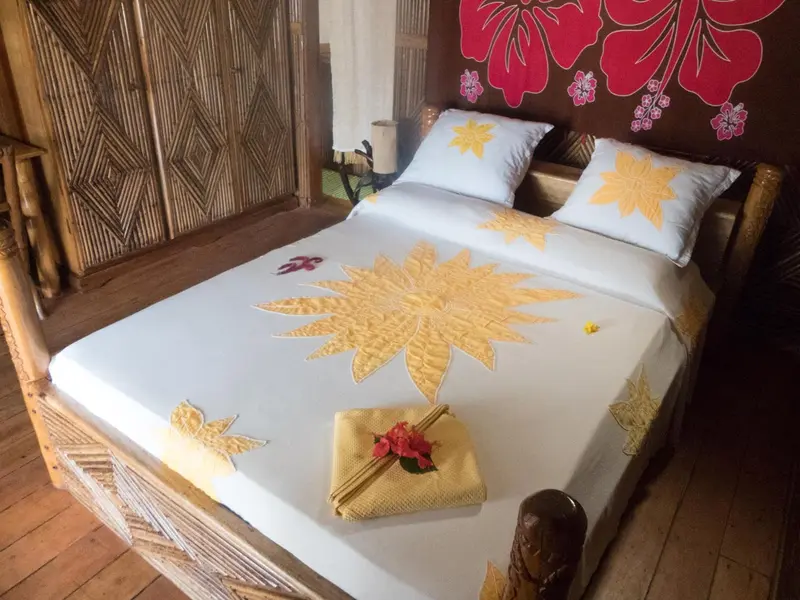 Lit décoré de fleurs et d'oreillers dans une chambre.