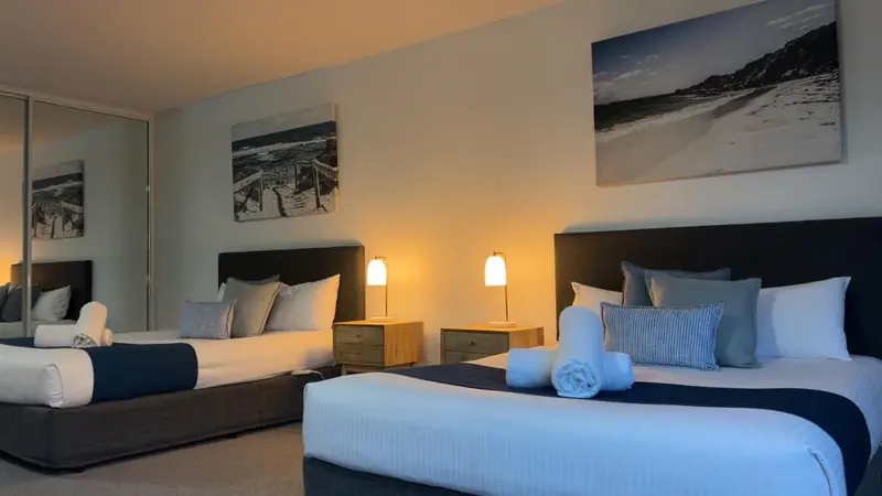 Chambre avec deux lits et décoration sobre.