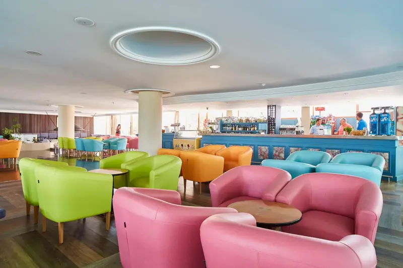 Un espace de détente coloré avec des fauteuils et un comptoir de bar.