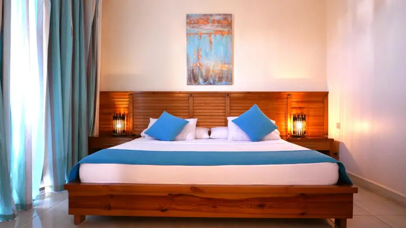 Une chambre lumineuse avec un grand lit et une décoration sobre.