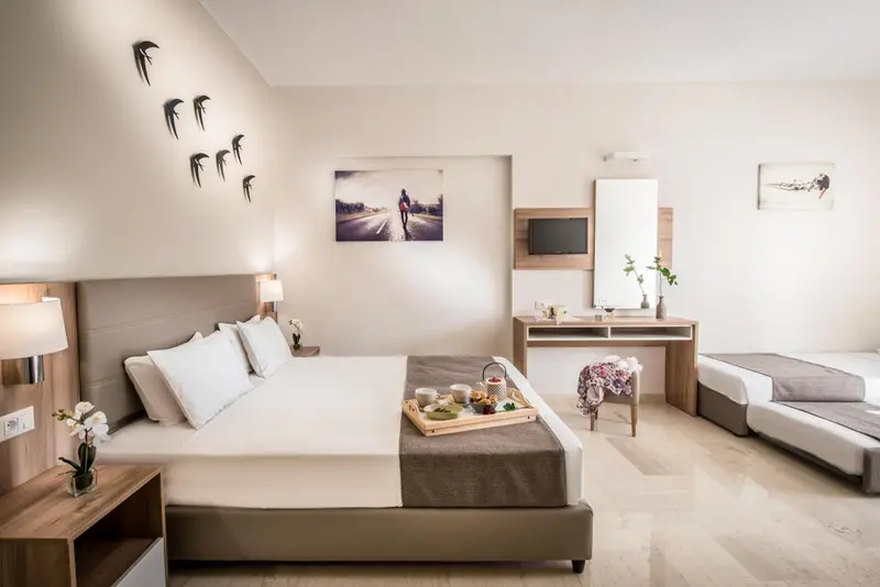 Chambre avec un grand lit et un coin repas.