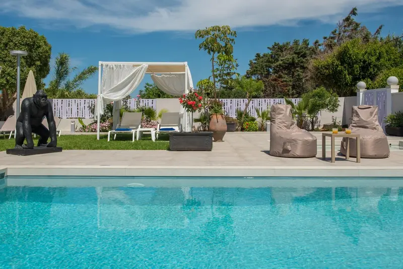 Espace de détente extérieur avec piscine et mobilier de jardin.