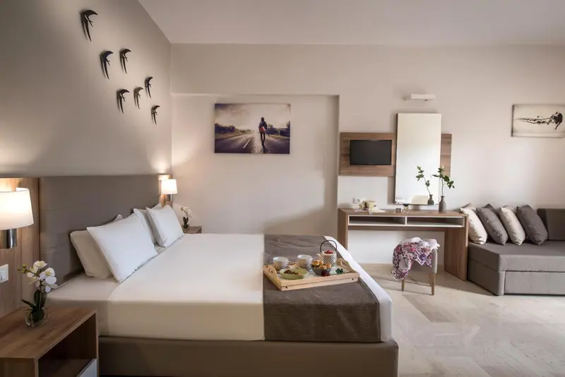 Une chambre lumineuse avec un grand lit et un espace détente.