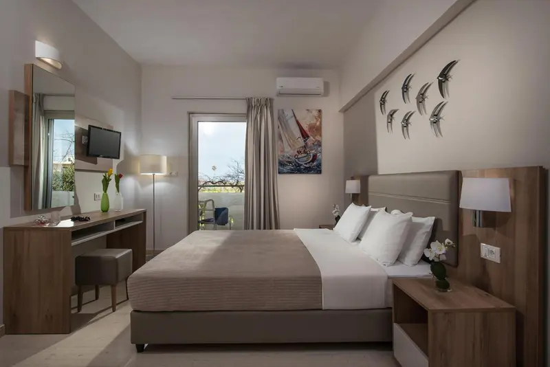 Une chambre lumineuse avec un grand lit et une vue sur l'extérieur.