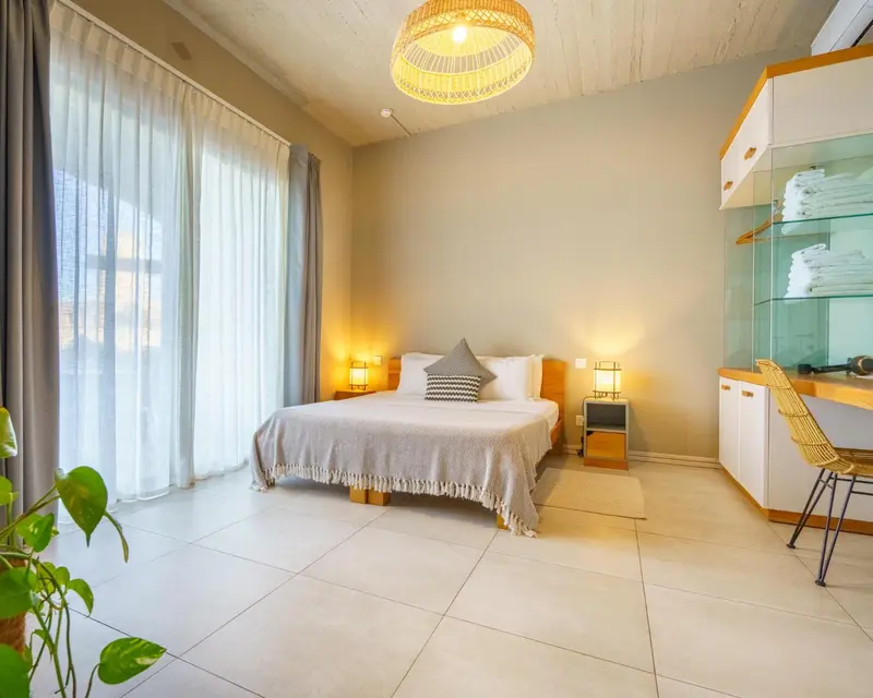Une chambre lumineuse avec un grand lit et une décoration sobre.
