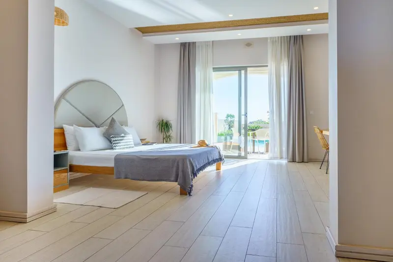 Une chambre lumineuse avec un grand lit et un accès à une terrasse.