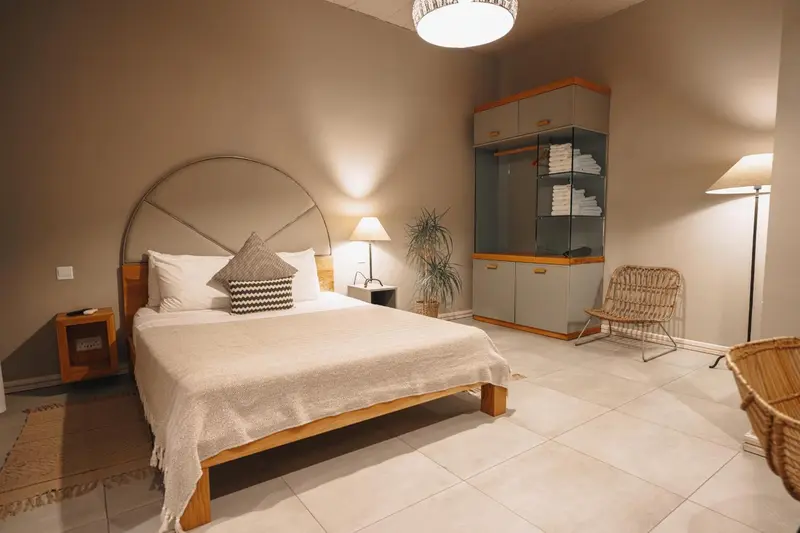 Une chambre lumineuse avec un grand lit et un meuble de rangement.