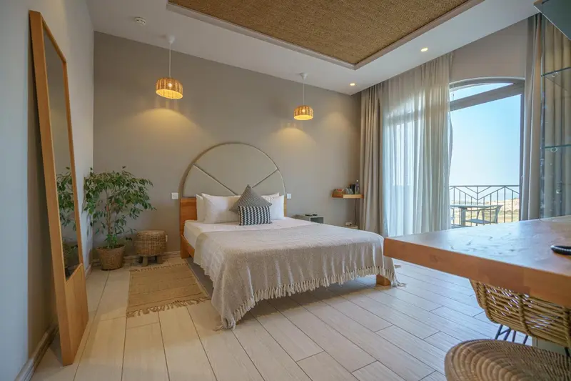 Une chambre lumineuse avec un grand lit et un accès à une terrasse.