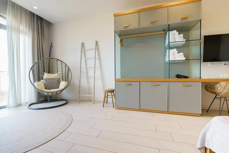 Une chambre lumineuse avec un coin lecture et un espace de rangement.