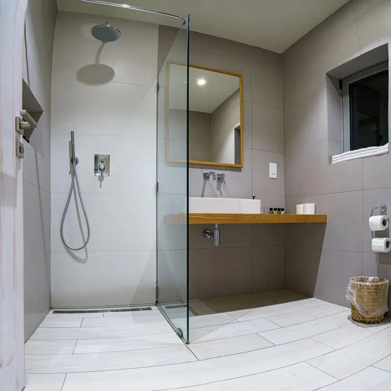 Une douche à l'italienne moderne avec des parois en verre et un carrelage gris.